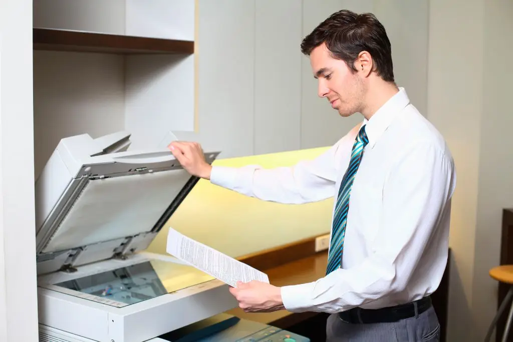 Pracownik biurowy wykorzystujący kserokopiarkę